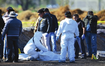 法医在爆炸现场处理遇难者遗体。新华社照片