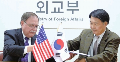 韩国外交部韩美防卫费分担谈判代表张元三（右）和美方谈判代表蒂莫西·贝茨在韩国首尔的外交部大楼签署协定。□新华社照片