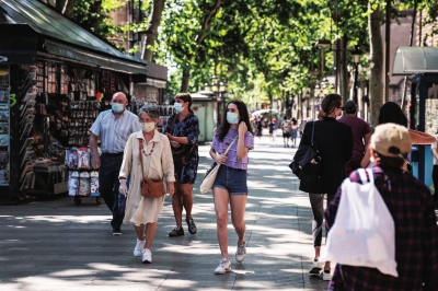 7月9日，在西班牙加泰罗尼亚自治区首府巴塞罗那，人们戴着口罩出行。新华社照片